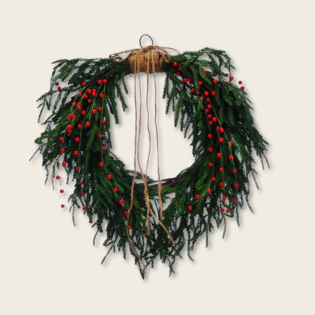 Green wreath with red berries on a beige background