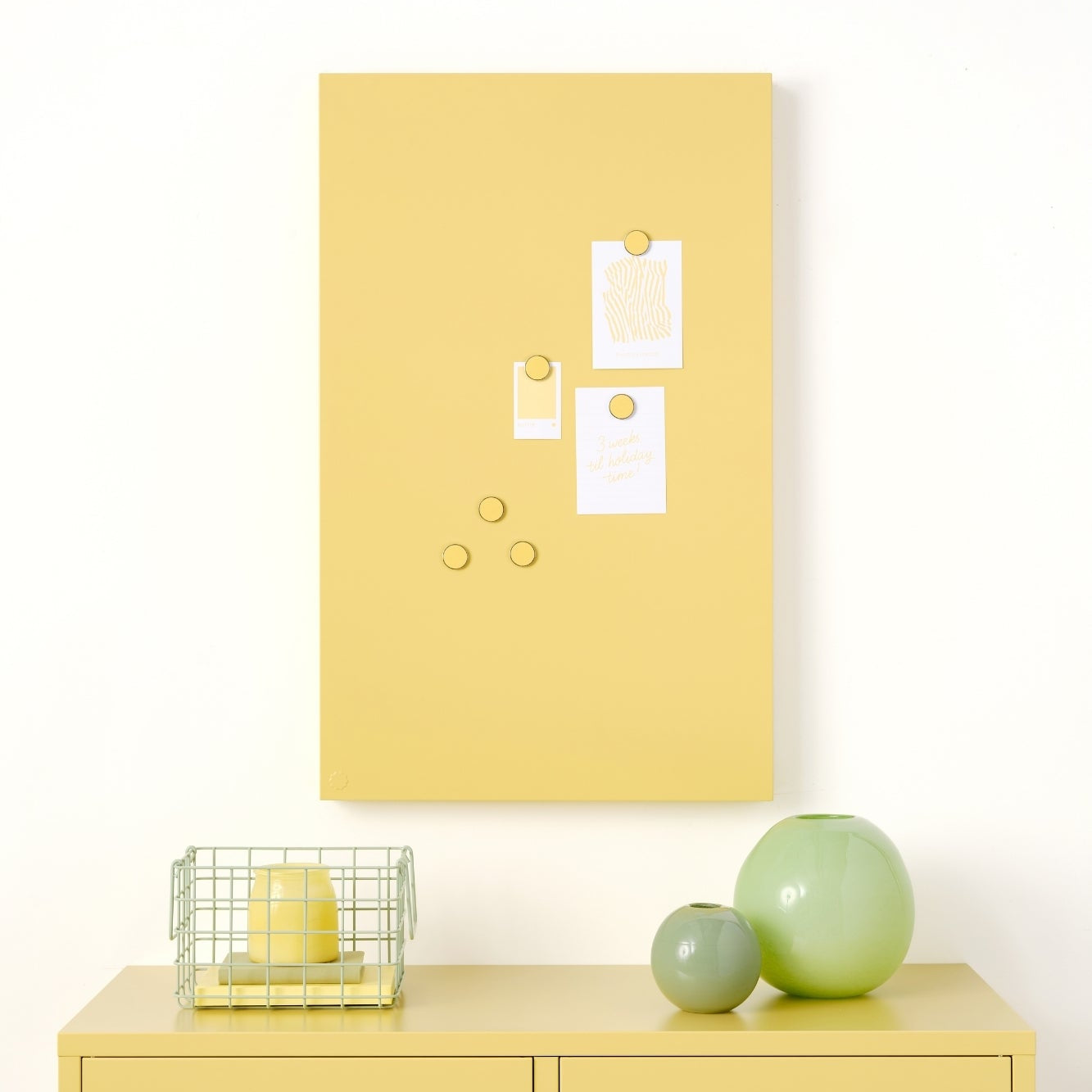 Yellow locker with a yellow bulletin board above it on a white wall.