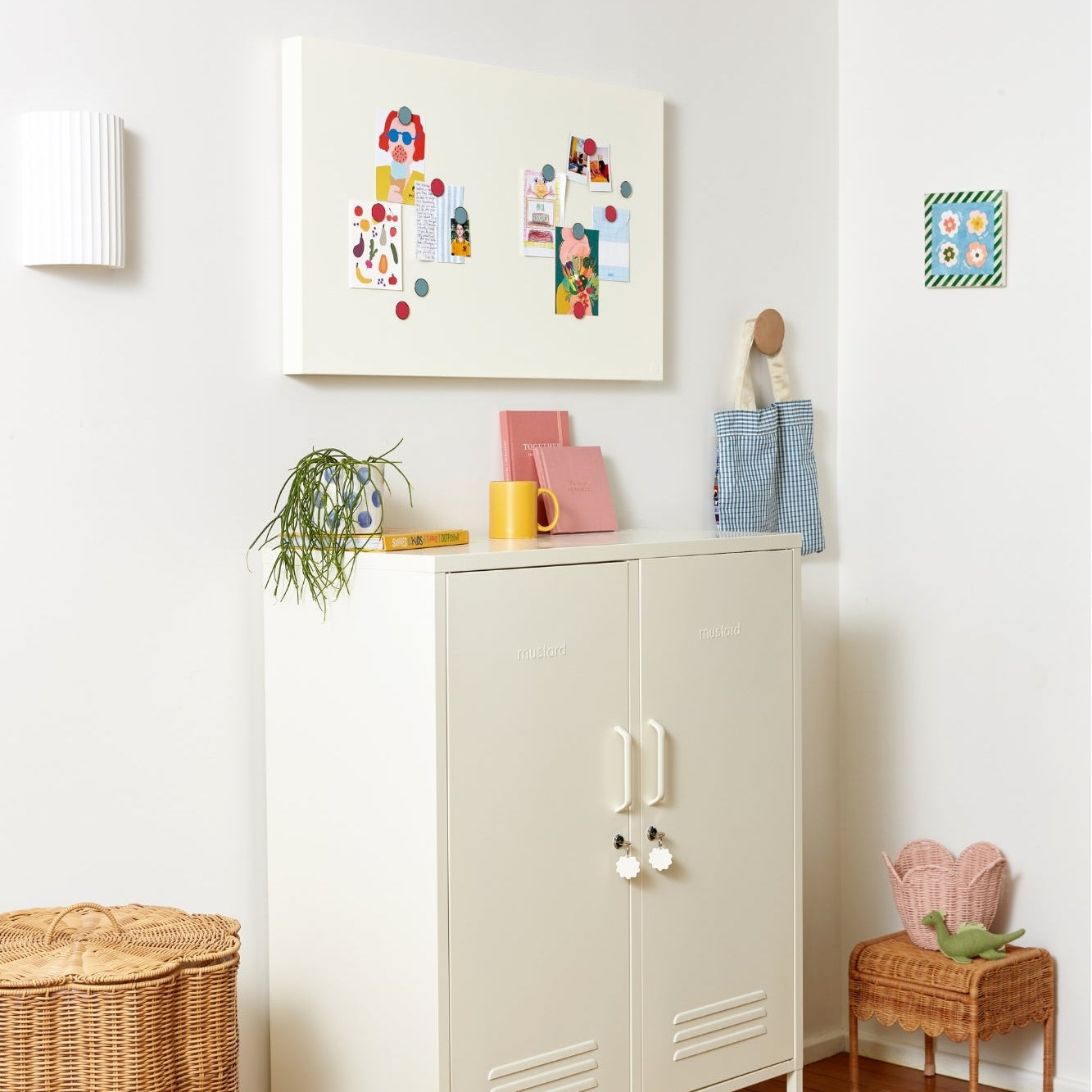 White cabinet with decorative items in a room with a white wall and wooden floor.