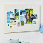 Desk with a decorative wall art piece, books, and a basket on a white tiled wall.