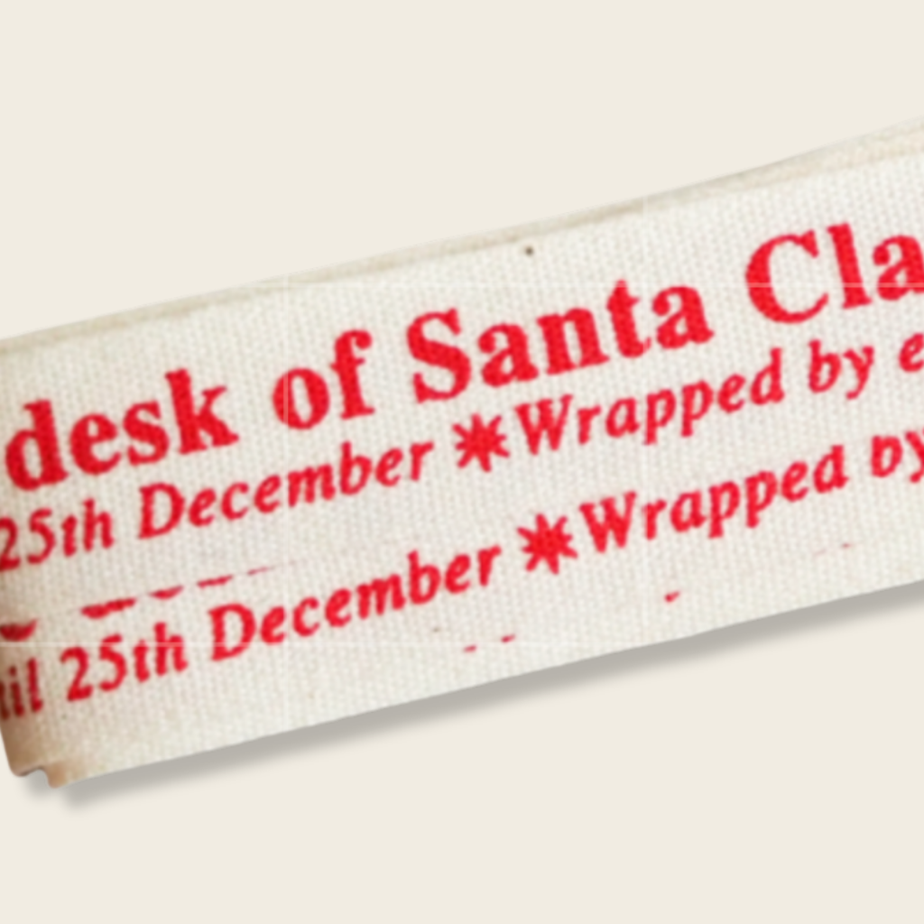Label with red text on a white background, likely for Christmas wrapping.