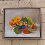 Framed painting of a still life with flowers on a brick wall