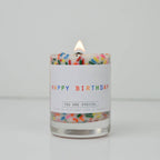 Candle with colorful sprinkles and 'Happy Birthday' label on a white background