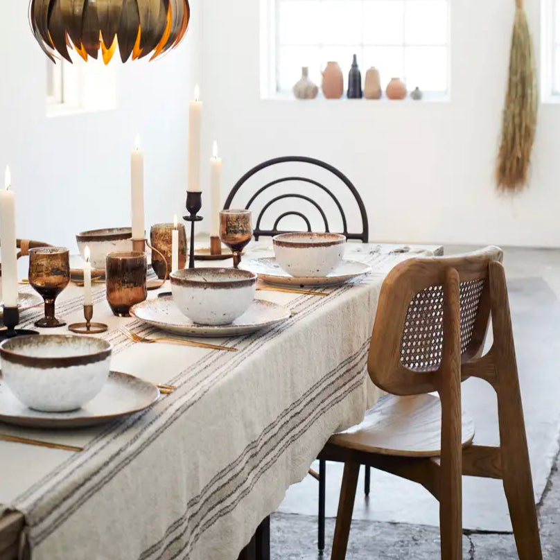 Dining room with a table set for dinner, featuring a pendant light and decorative elements.
