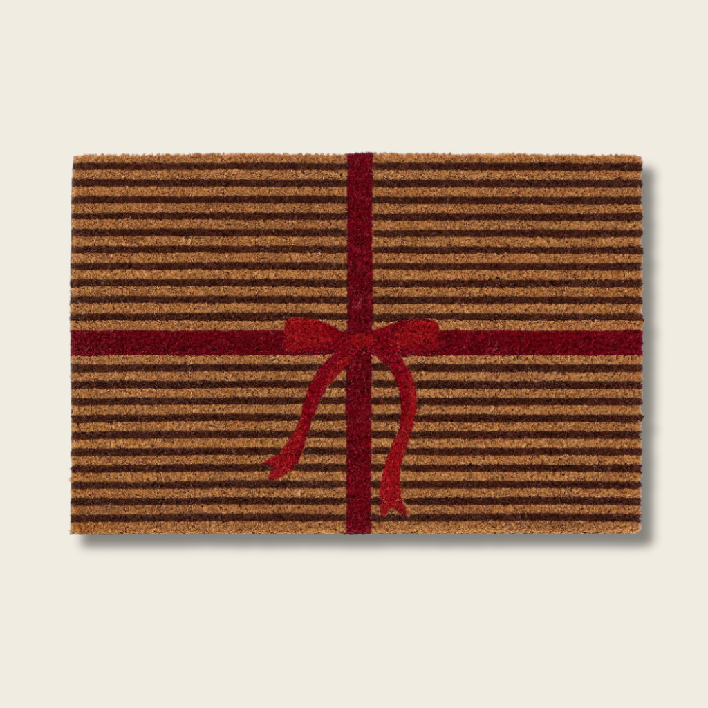 Doormat with brown stripes and a red bow on a beige background
