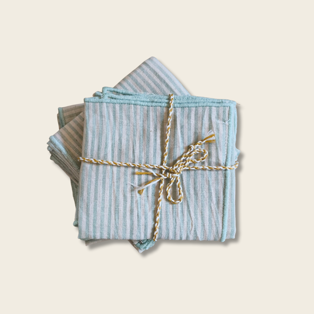 stripe blue and green cotton napkins tied with a string on a wooden table