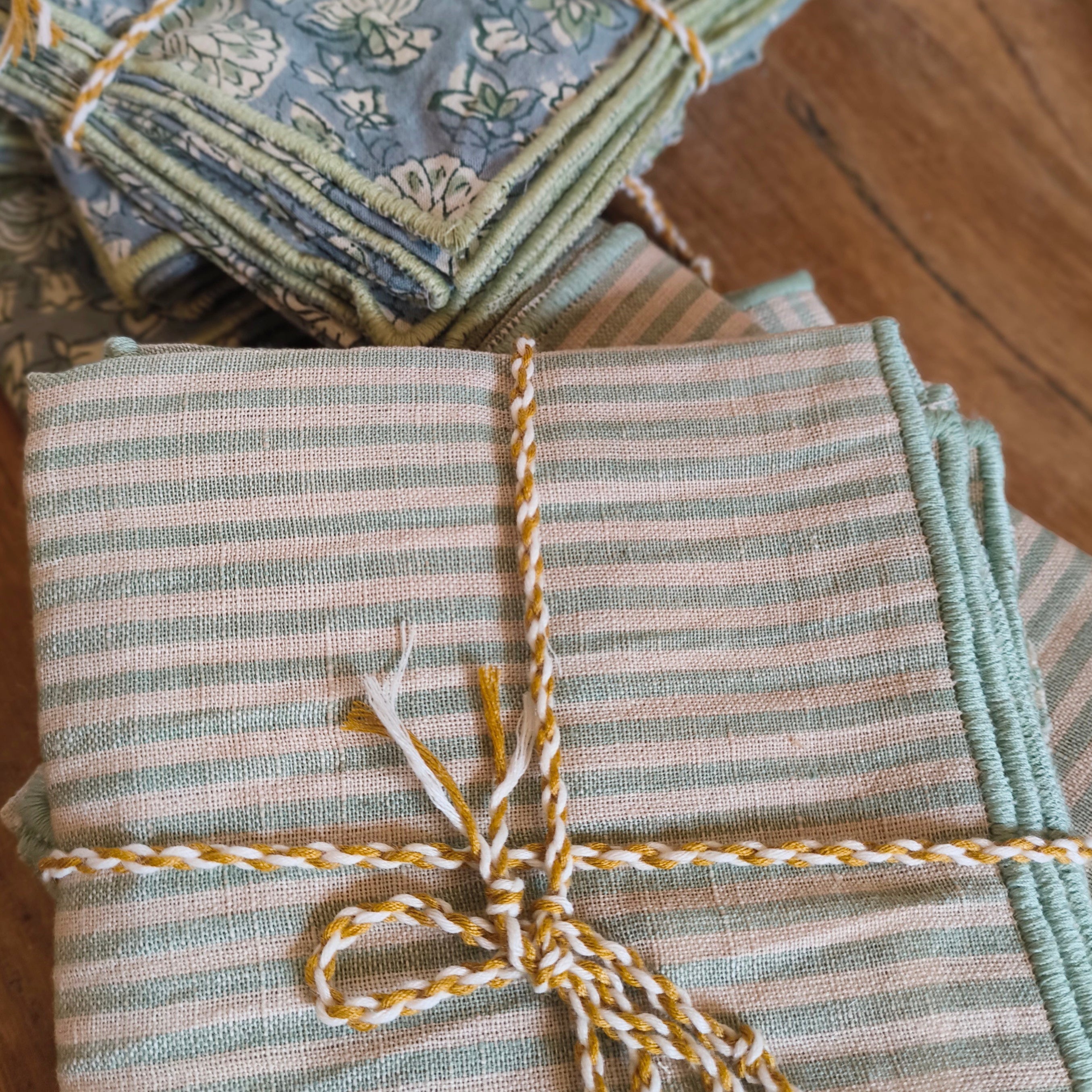 Packaged napkins with decorative string on a wooden surface