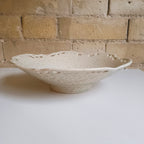 Ceramic bowl on a white surface with a brick wall background