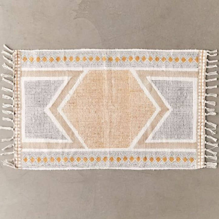 Textile with geometric pattern and tassels on a plain background
