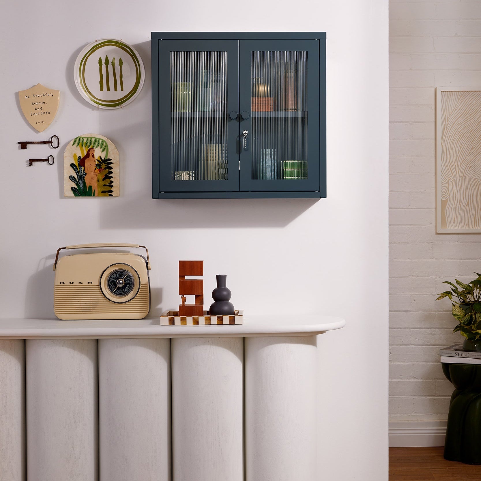 Grey cabinet on a white wall with decorative items below