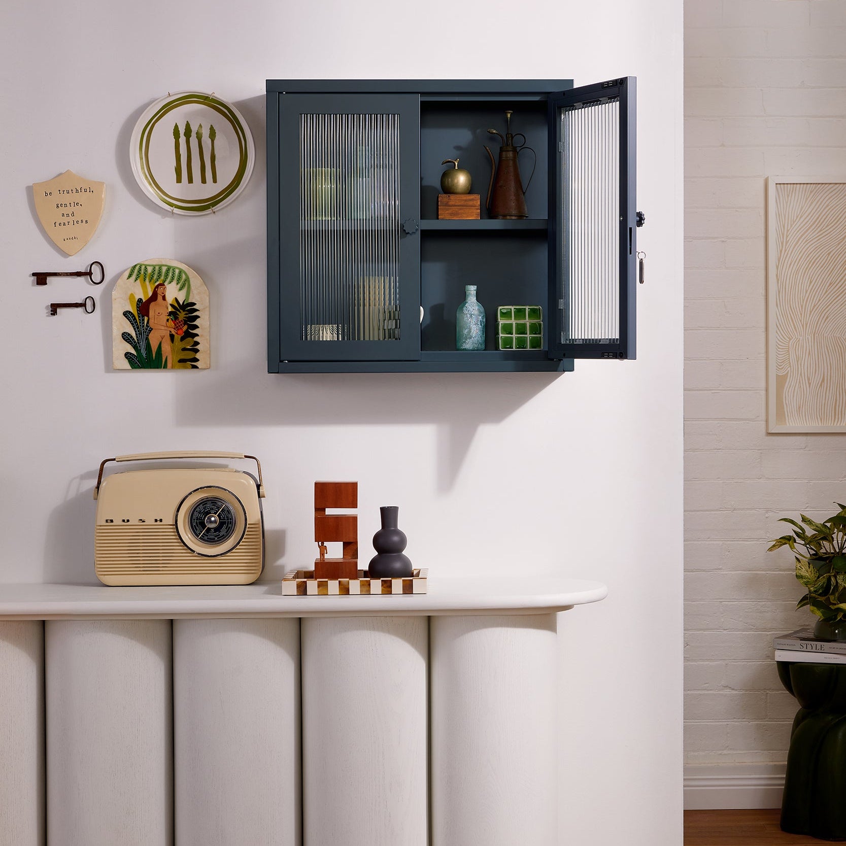 Modern interior with a cabinet, table, and decorative items on a white wall.