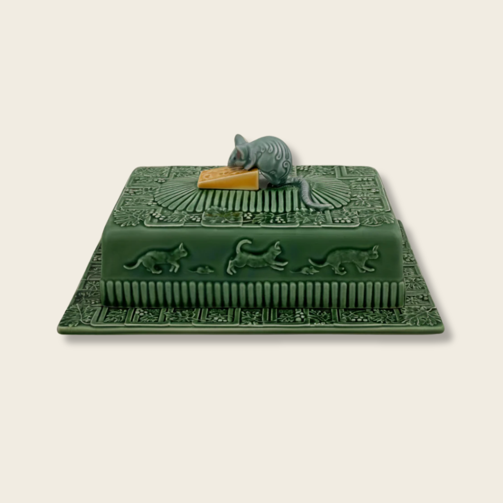 Decorative green cheese dish with animal carvings on a beige background