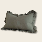 khaki green rectangle cushion with ruffle edge on a beige background