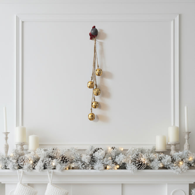 Decorative gold bell chain hanging on a white cabinet.