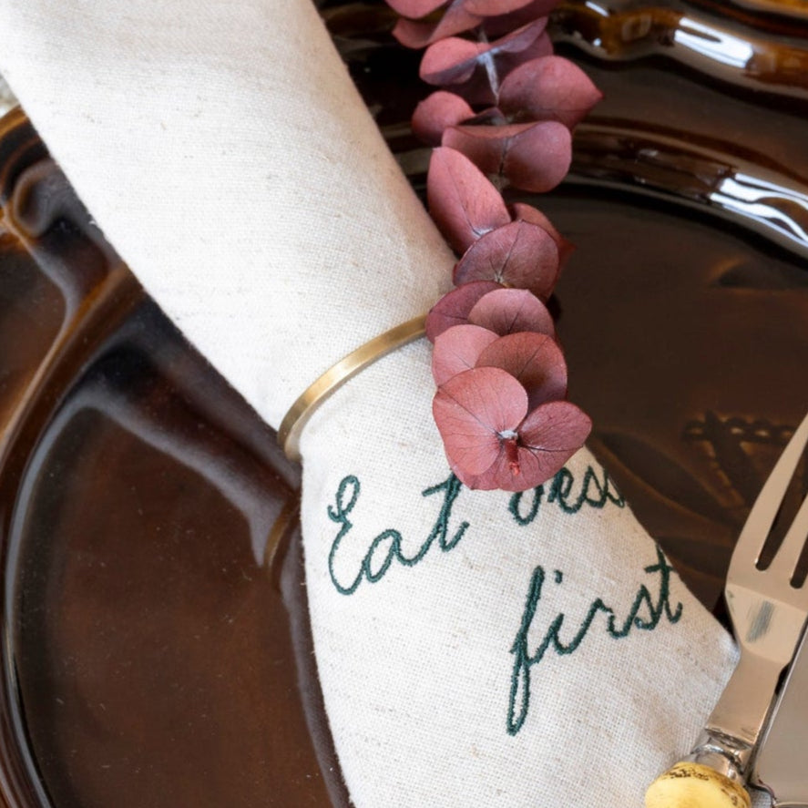 Table setting with brown plates, white napkin, and decorative elements on a wooden table.