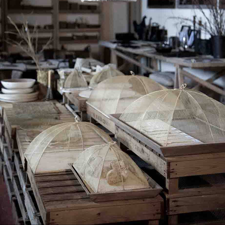 Wooden tables with fabric-covered umbrellas in a rustic setting