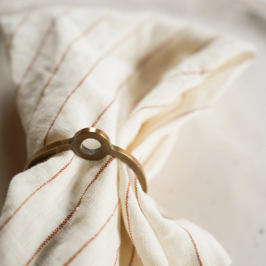 Napkin ring on a folded white napkin with red stripes