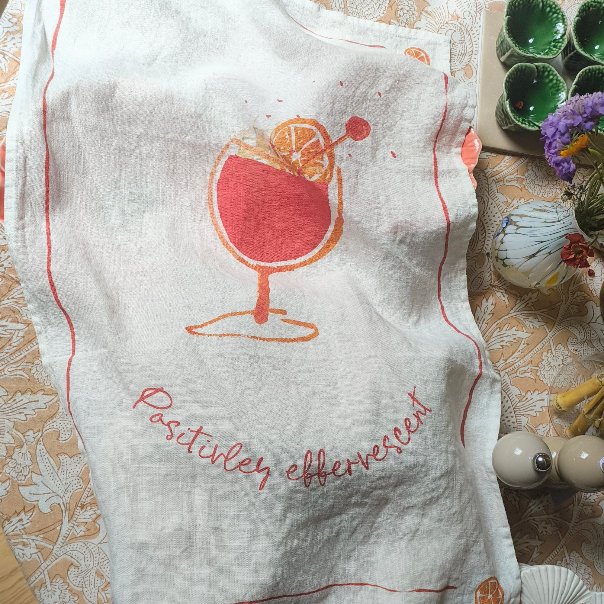 White towel with red design and text on a decorative table