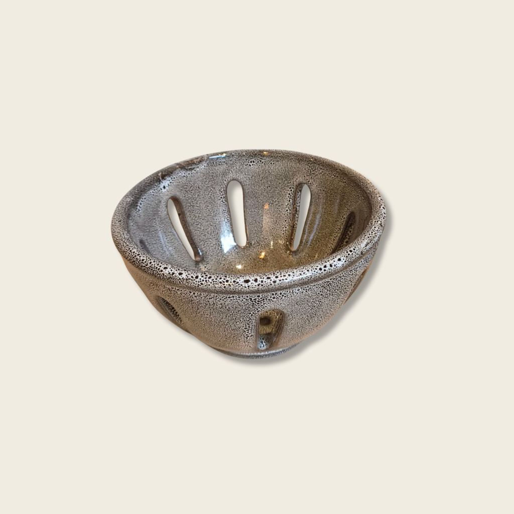 Tawny coloured speckled berry bowl on a beige background