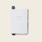 Light gray notebook with black strap on a beige background