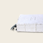 Close-up of a white book with a feather on a beige background