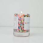 Candle with colorful sprinkles and a 'Happy' label on a white background