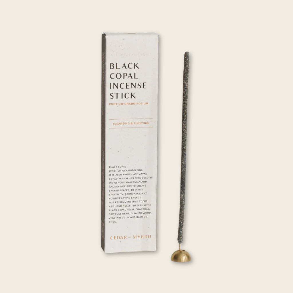 Black copal incense stick with packaging on a beige background