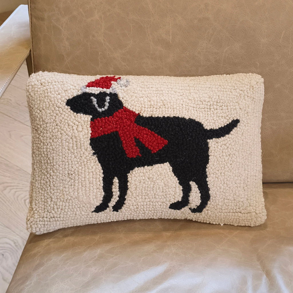 Decorative pillow with a black dog wearing a red scarf on a beige couch.