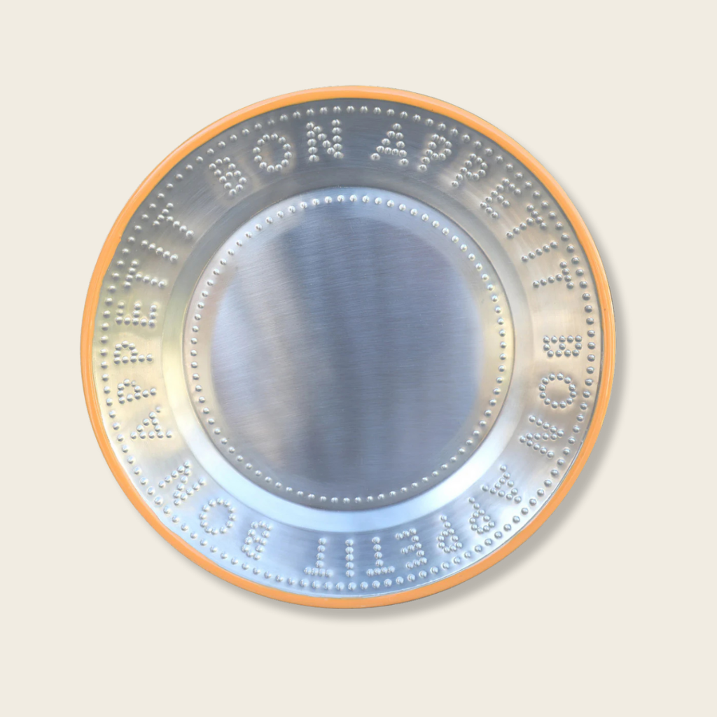 Circular metallic object with text and numbers on a beige background