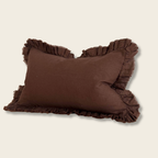 brown linen cushion with ruffle edges on a beige background