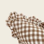 Brown and white checkered fabric with ruffled edge on a beige background