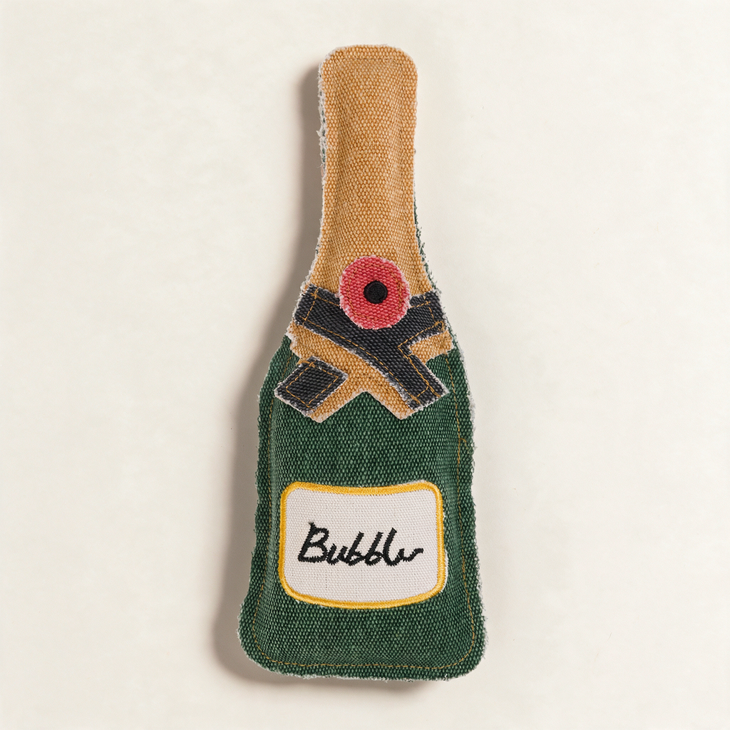 Canvas dog toy shaped like a bottle of fizz, on a cream background