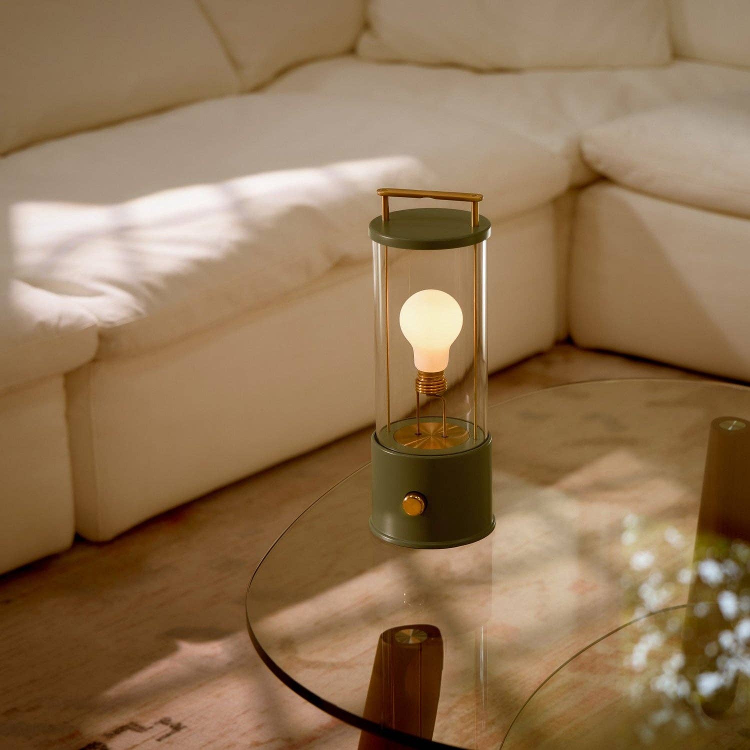 Lamp with a light bulb inside on a glass table in a living room.