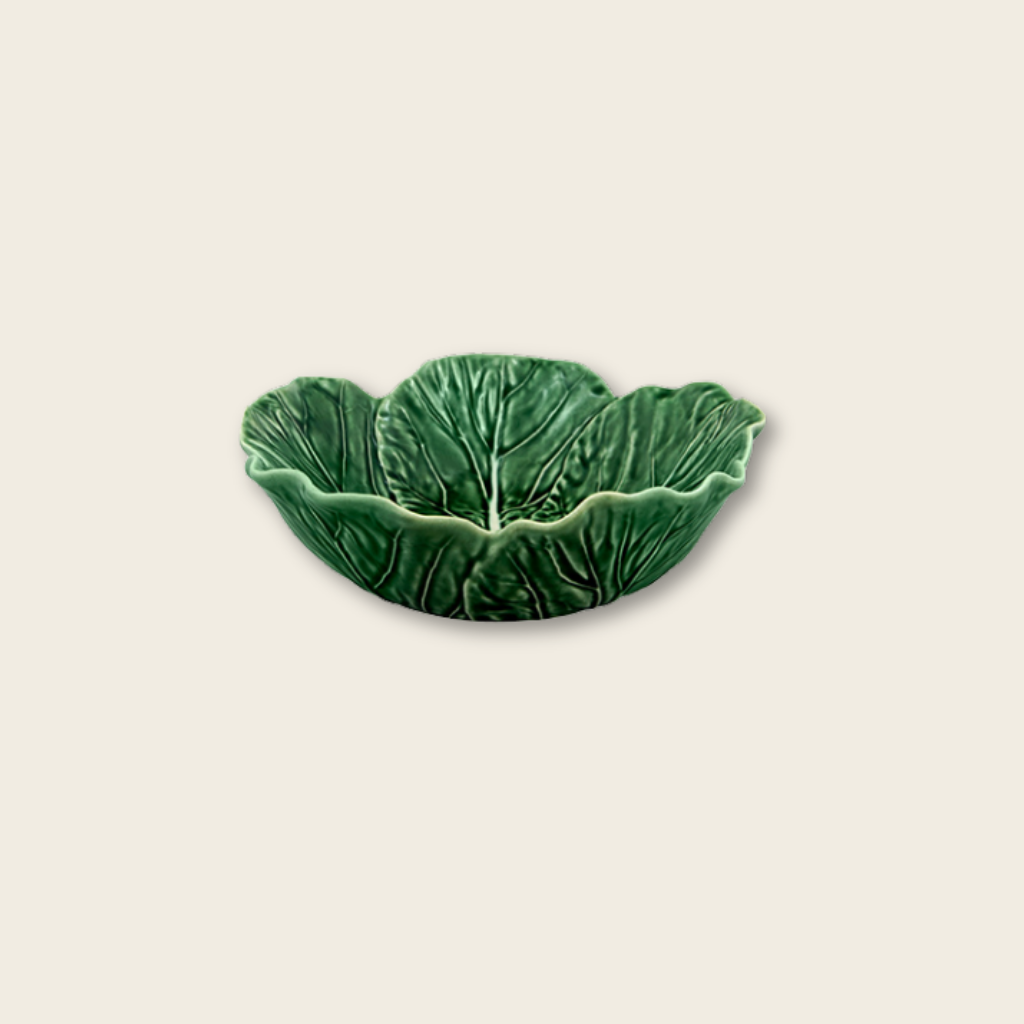 Green ceramic dish shaped like a cabbage leaf on a beige background