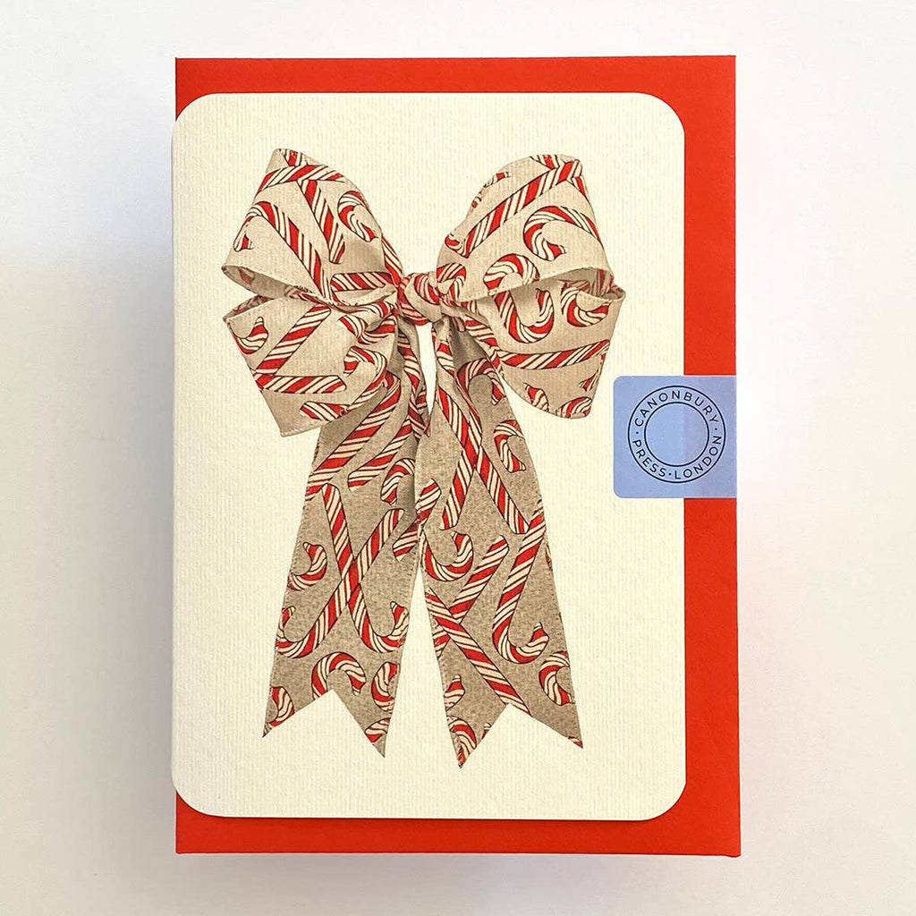 Card with a candy cane bow design on a beige background with a red border.