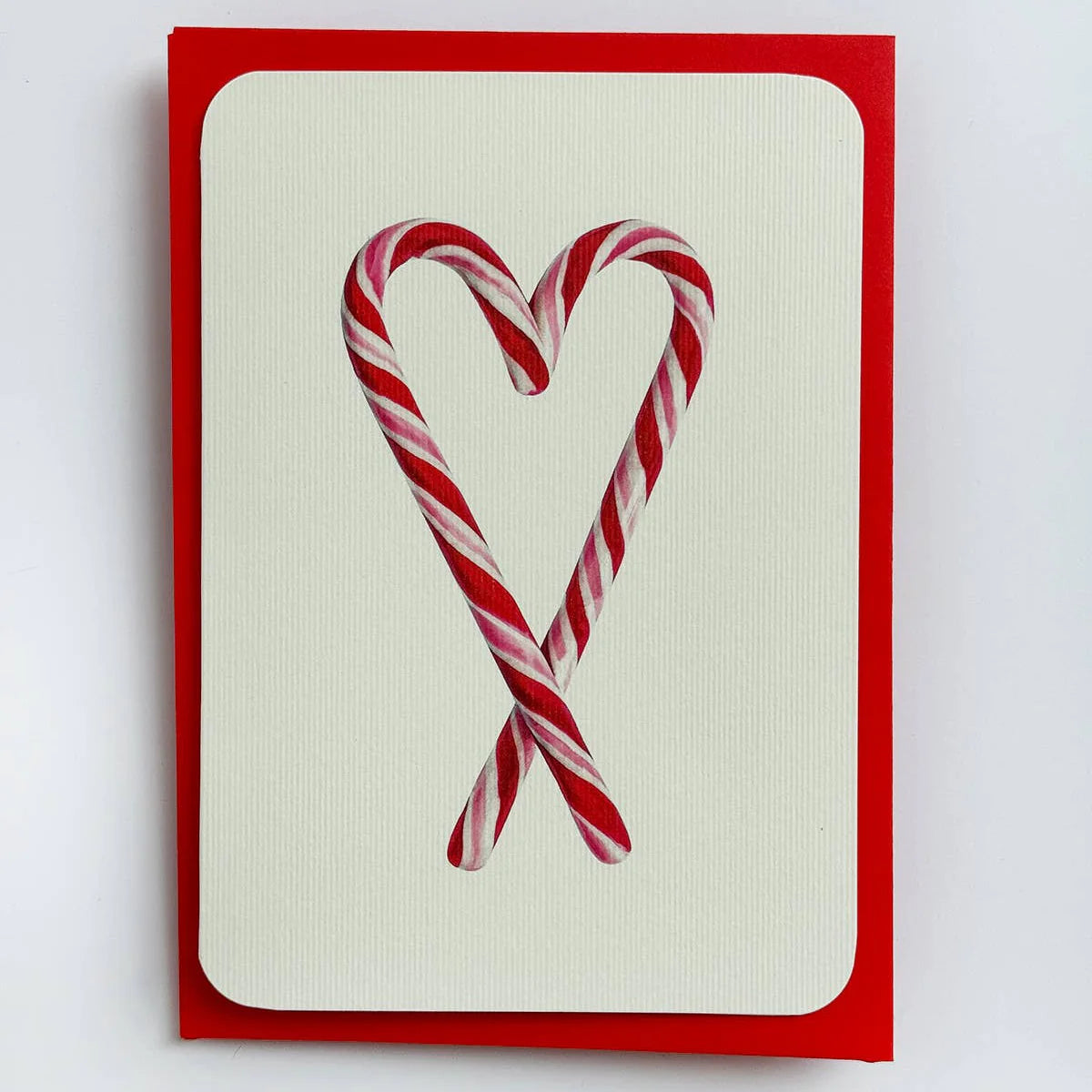 Card with two candy canes forming a heart shape on a white background