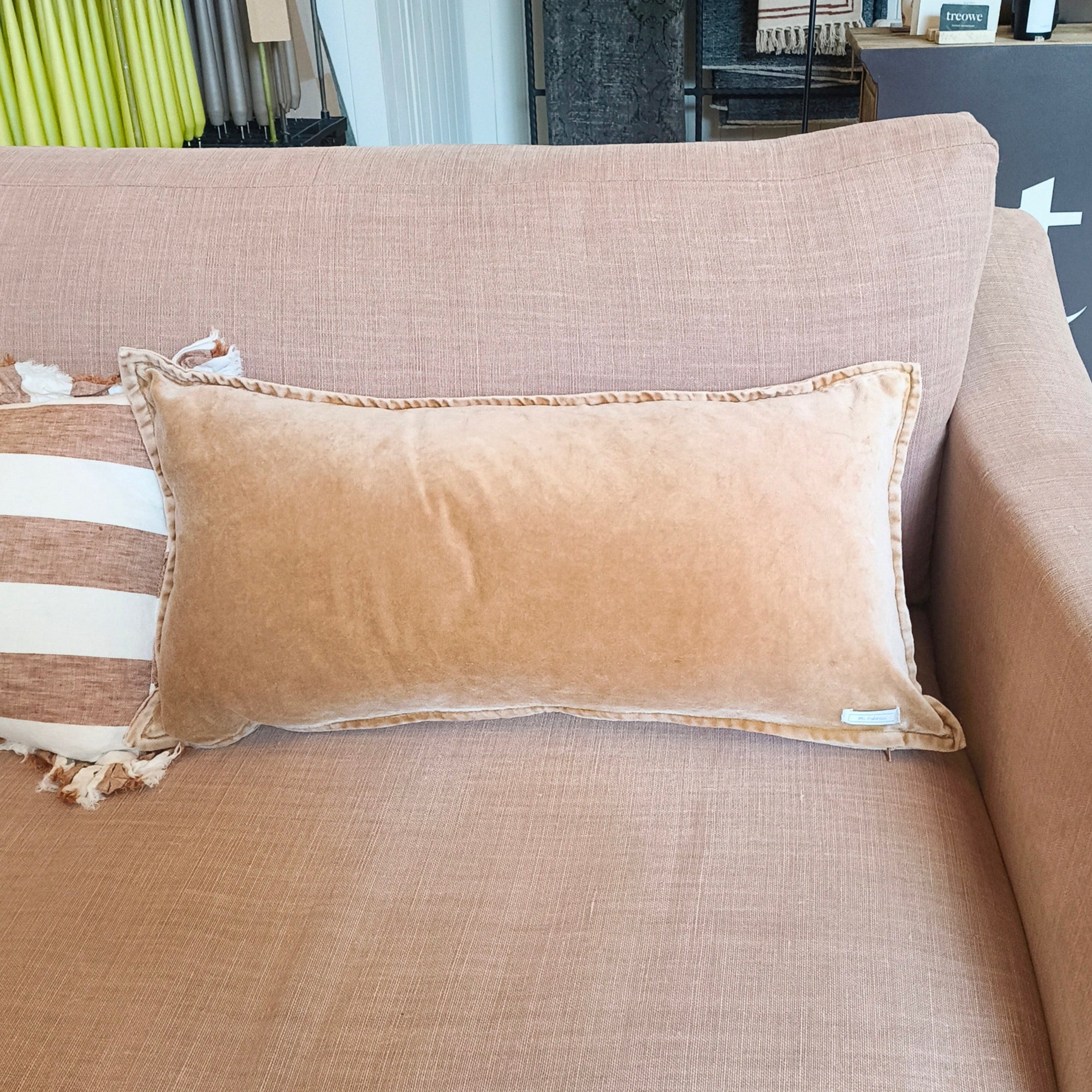 Dusk pink sofa with decorative pillows in a store setting