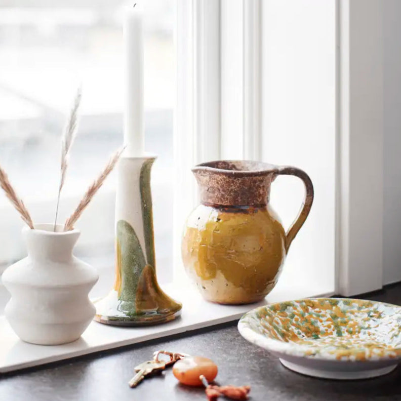 Decorative ceramic items on a windowsill with soft lighting