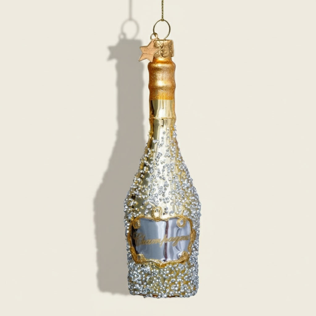 Decorative champagne bottle ornament with gold and silver glitter on a white background