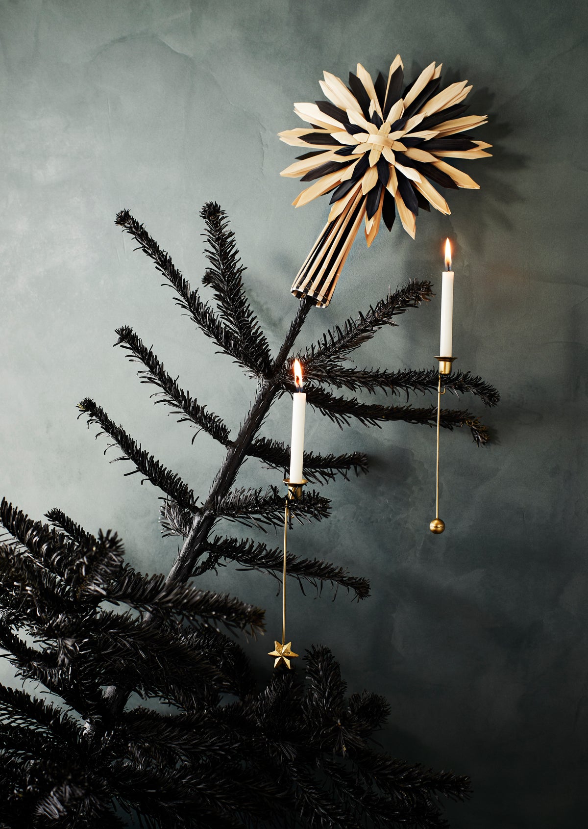 Brass Christmas tree candle holder styled with a lit candle