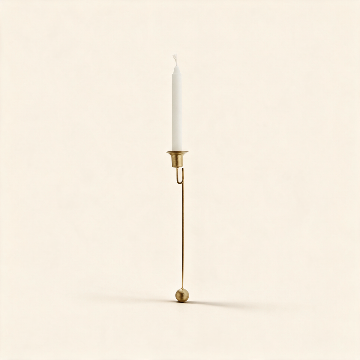 Christmas tree shaped candle holder in antique brass on a warm cream background