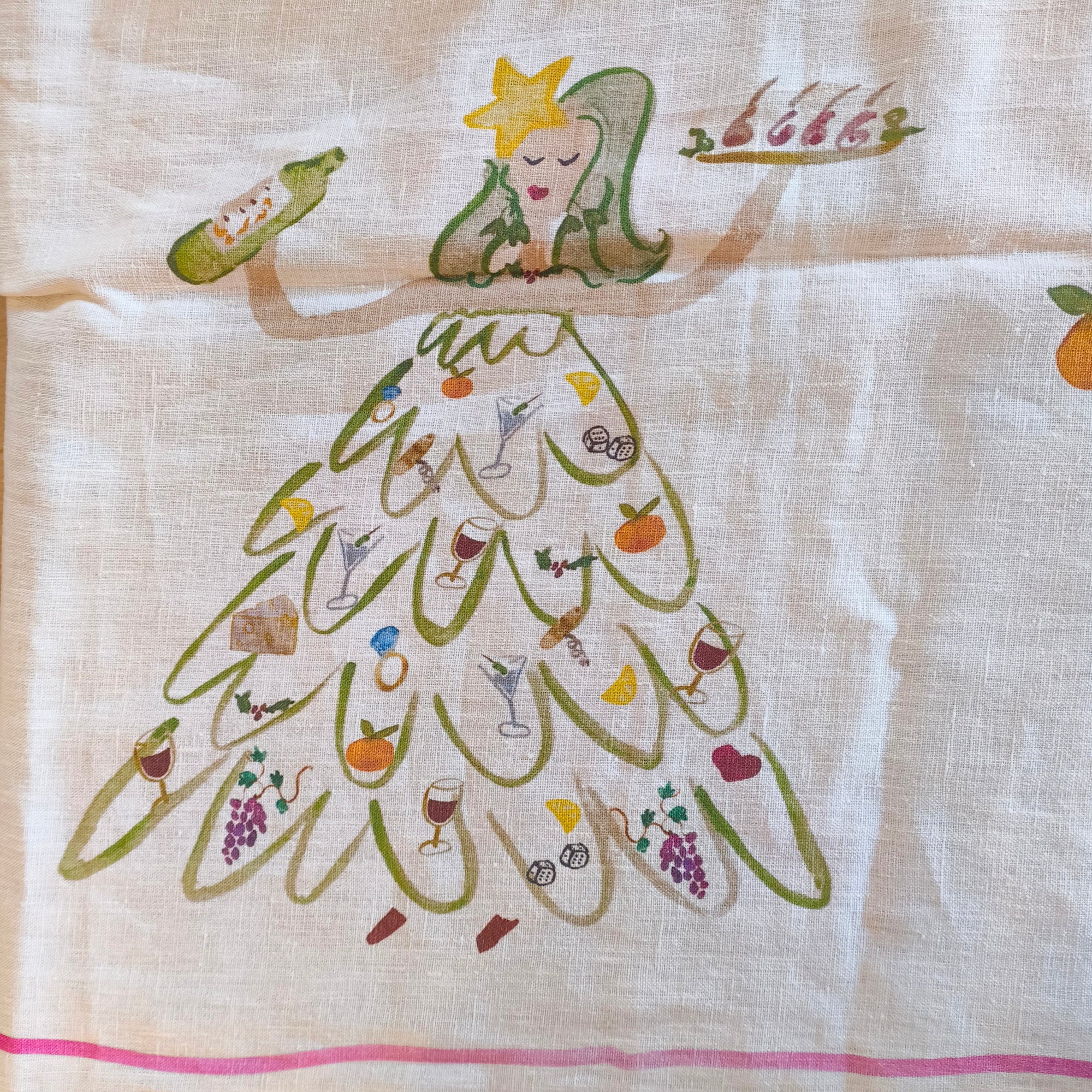 Decorative table cloth with a cartoon character in a dress made of food items on a wooden surface.