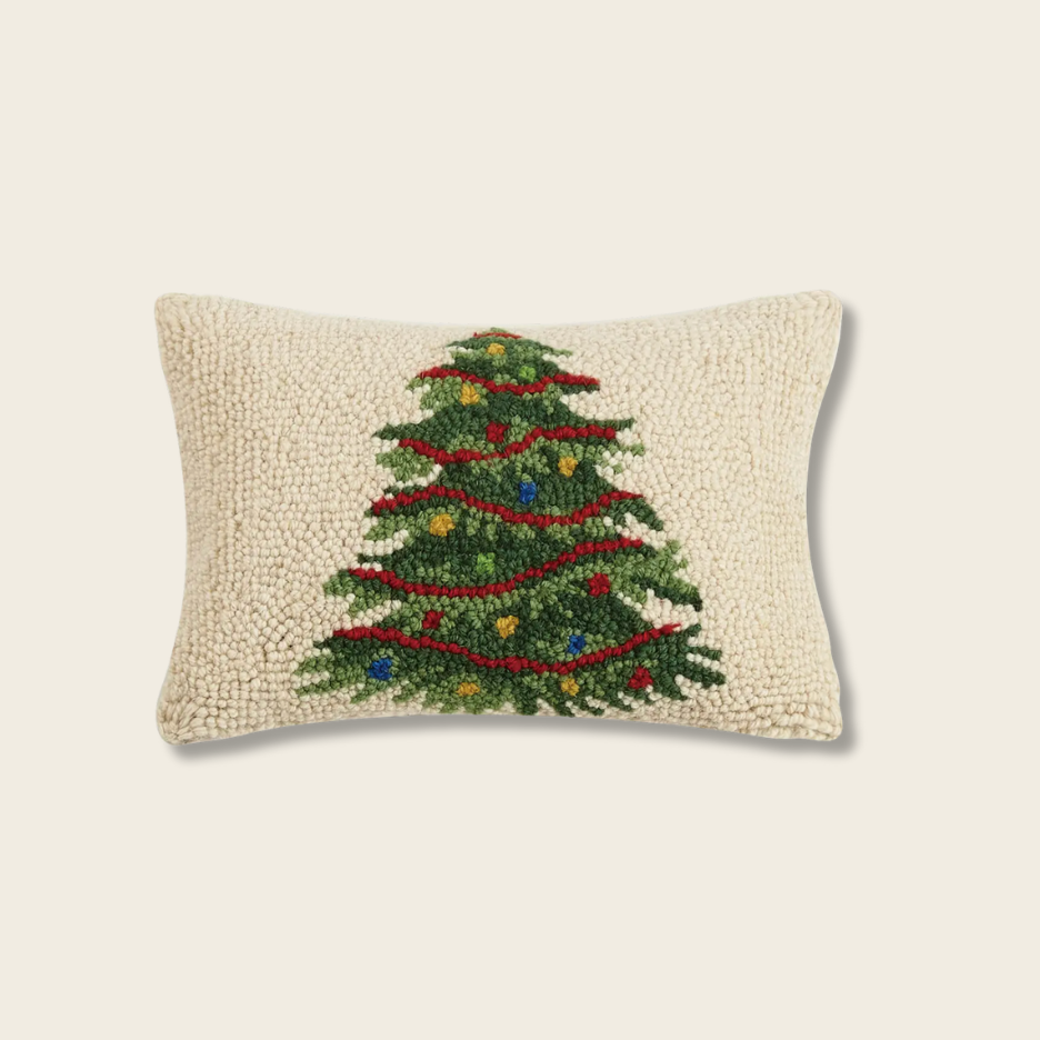 Decorative pillow with a Christmas tree design on a beige background
