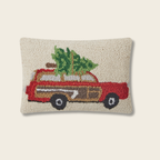 Decorative pillow with a red truck carrying a Christmas tree on a beige background