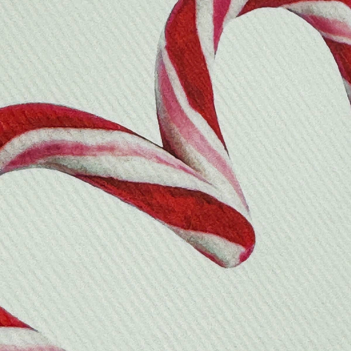 Close-up of red and white striped candy canes on a textured surface