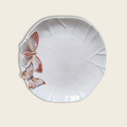 white ceramic dinner plate with two butterflies on a beige background