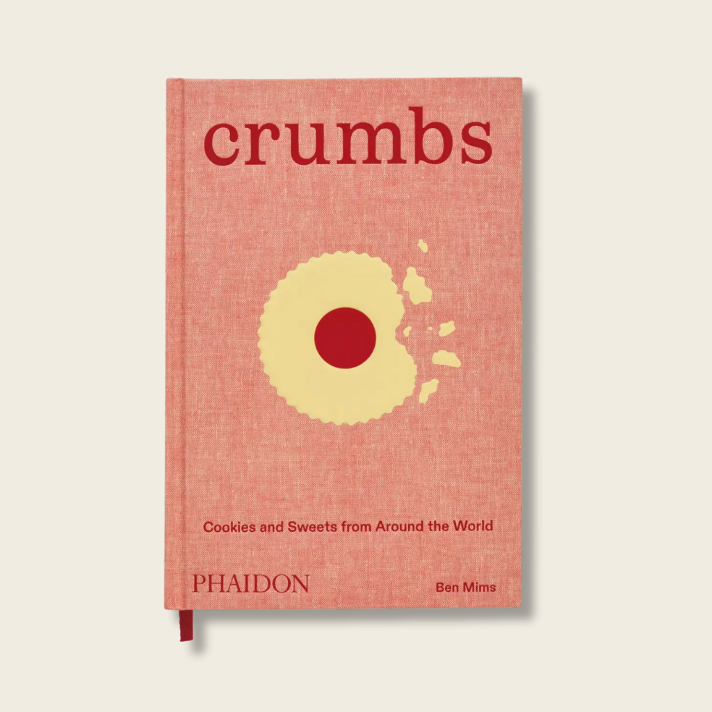 Book titled 'crumbs' with a red cover and yellow circle on a beige background