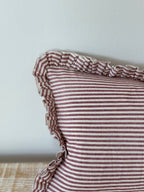 Detail of the burgundy stripe and ruffle trim on the Darcy cushion cover