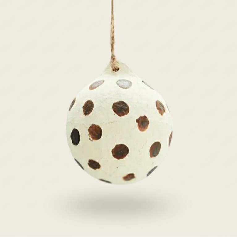 Decorative egg-shaped ornament with brown polka dots on a white background