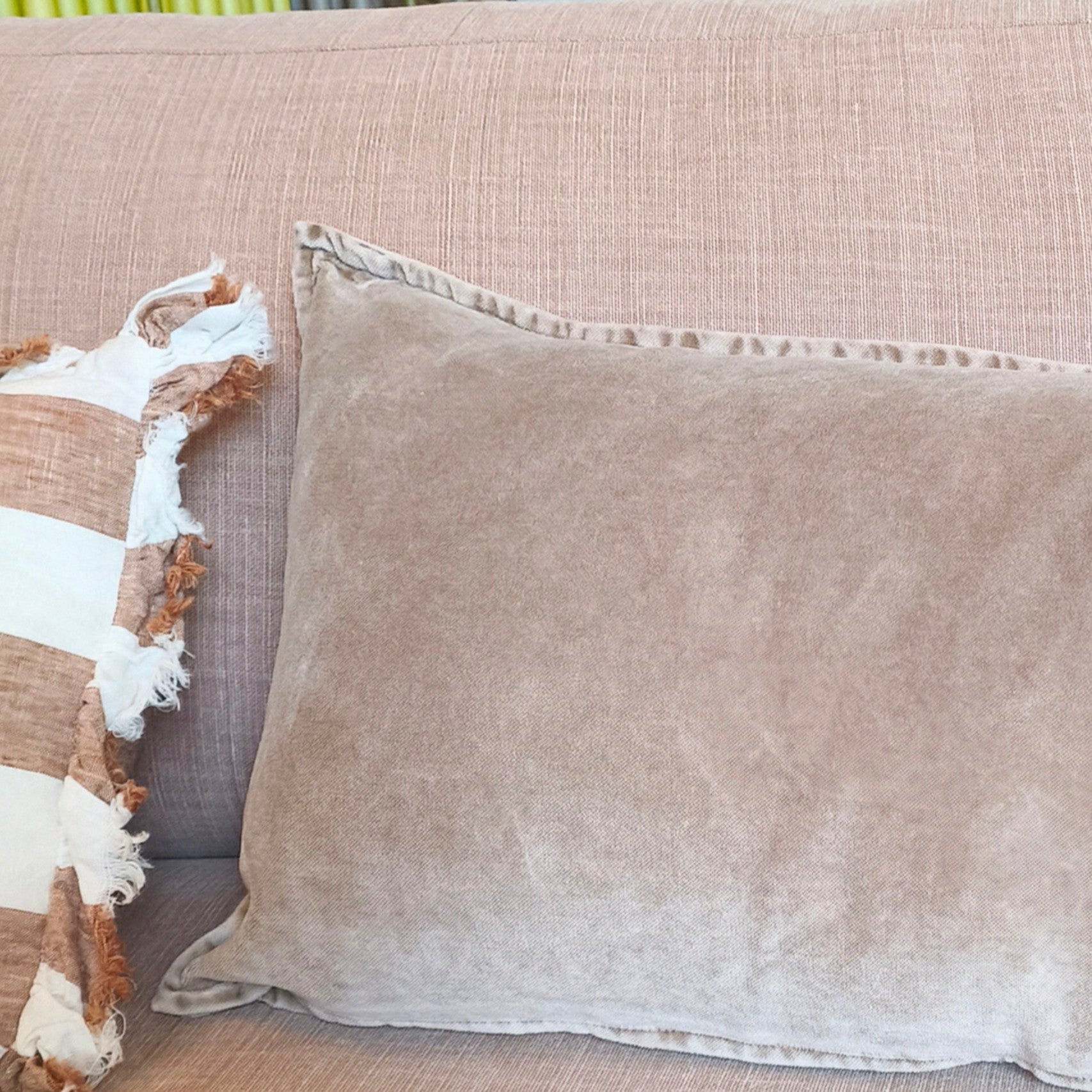 Beige sofa with decorative pillows in a living room setting